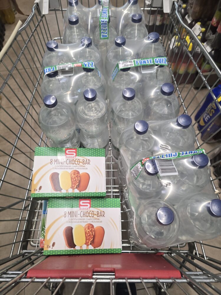 Wasserflaschen und Schokoriegel im Einkaufswagen