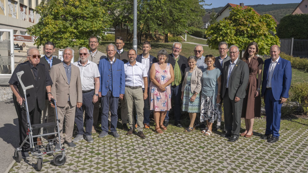 Gruppe von Personen in Tracht und Anzügen vor einem Gebäude in Hafnerbach